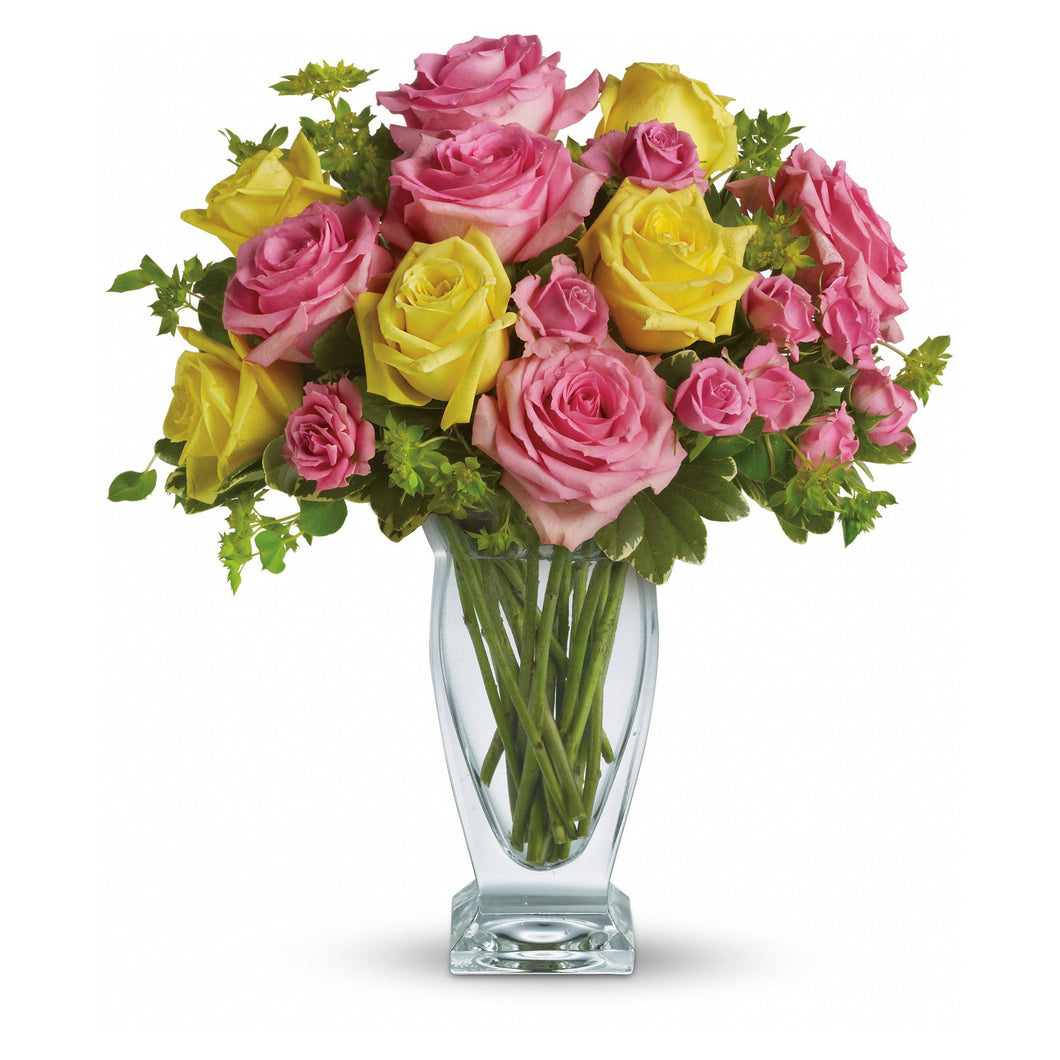 Pink and yellow roses arranged in a clear glass vase, in Flower Studio's signature style.